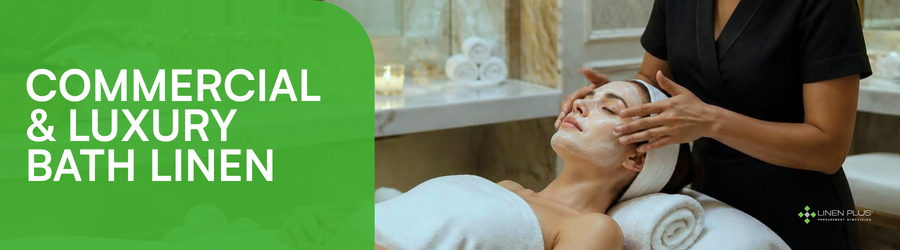 A spa therapist in black gently massages a person’s face and shoulders on a treatment bed, with rolled white towels and candles in a bright, elegant room.